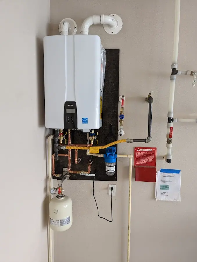 Professional plumber installing copper piping in a Warren home